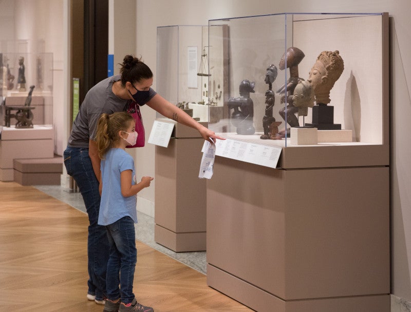 A visitor points out an object's label to a child