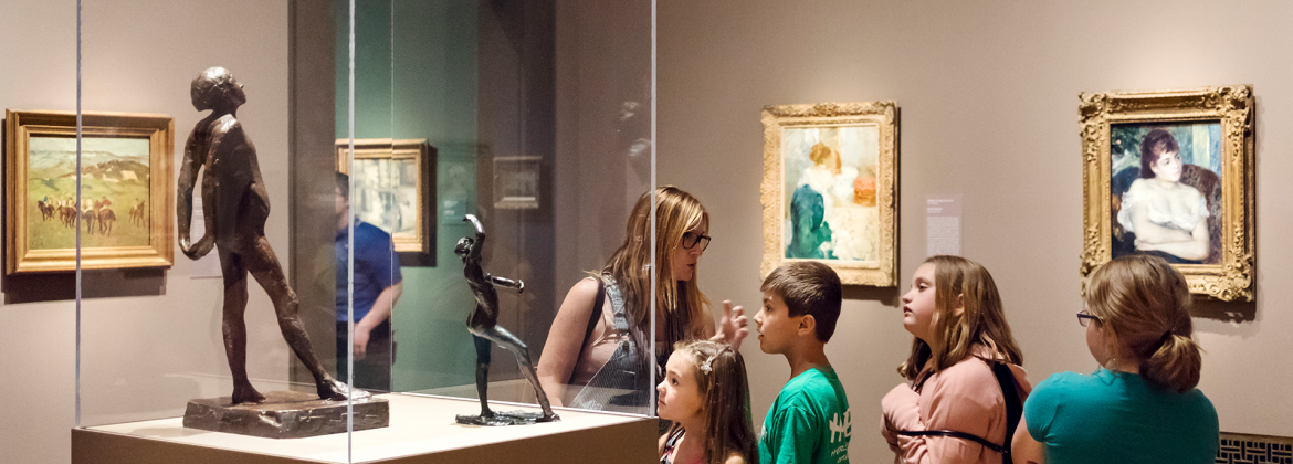 A family viewing a Degas sculpture in Humble and Human: Impressionist Era Treasures